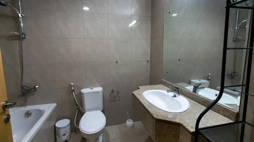 This photo shows a bathroom next to a bed space customized for rent in Dubai Marina at an exclusive price.