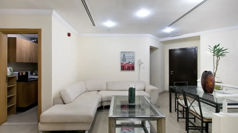 this picture includes a table and sofa in a bed space available for rent in Marina at an exclusive price.