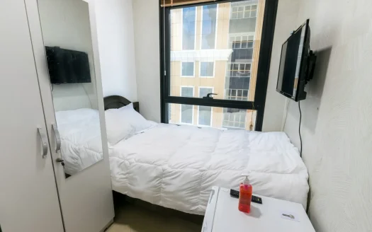 this picture shows a bed and screen inside a room in marina customized for rent at a cheap price.