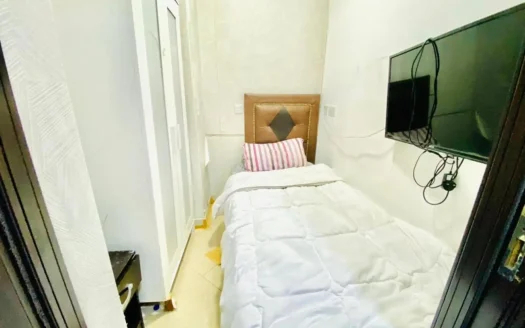 this image shows a bed and screen in a single room for rent in Dubai Marina at an exclusive price.