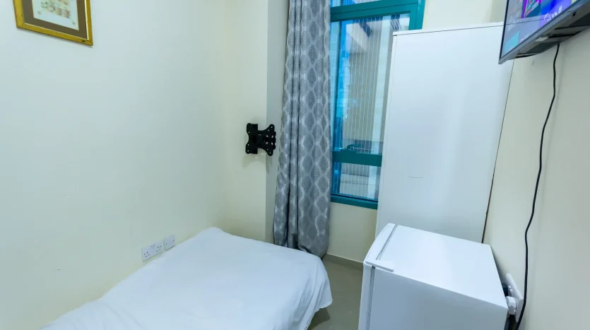 This picture includes a single bed and screen inside a private room available for rent in Marina Dubai.
