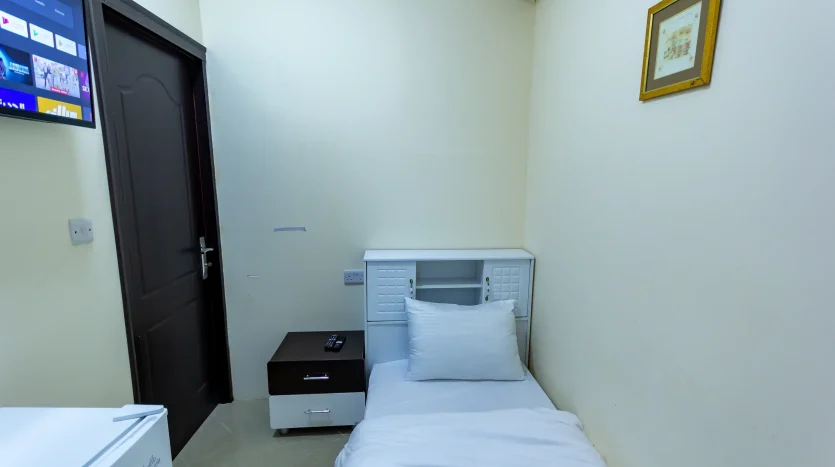 this photo includes a bed and screen and treasury inside a solo room for rent in Dubai