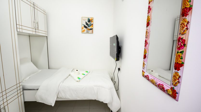 This picture shows a bed and screen TV in a Partition in Al Qusais - Dubai